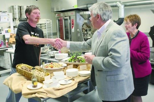 Men Shaking Hands Over Table of Food